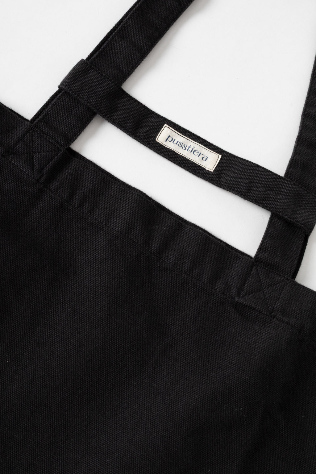 pusstiera tote bag An elegant sustainable cotton canvas tote bag, eco-friendly, premium Swedish design with Scandinavian quality, made in Europe, in limited edition numbered bags. Black caviar color with four utility loops and a stabilizing strap