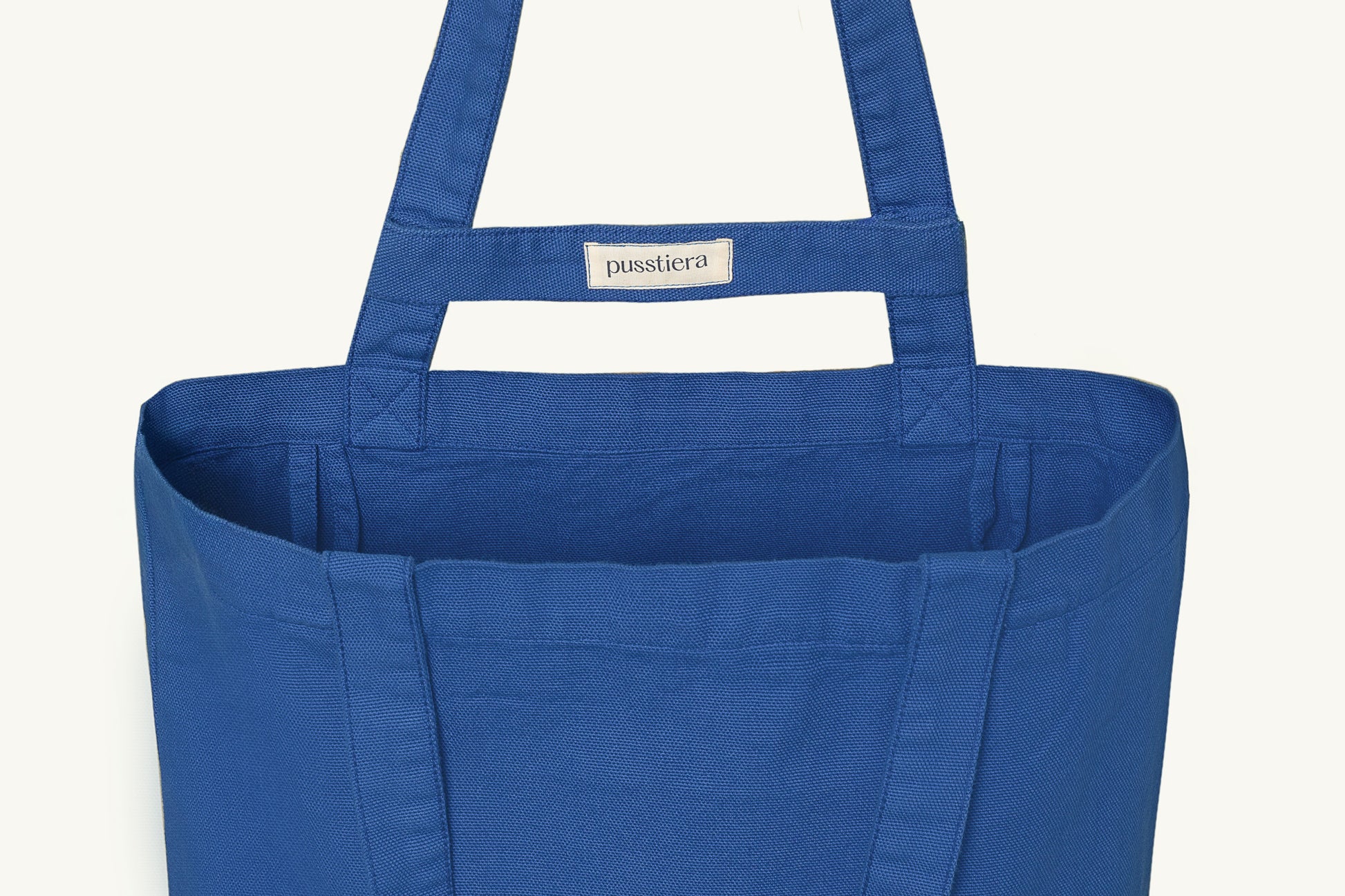 pusstiera tote bag An elegant sustainable cotton canvas tote bag, eco-friendly, premium Swedish design with Scandinavian quality, made in Europe, in limited edition numbered bags. Classic blue color with four utility loops and a stabilizing strap