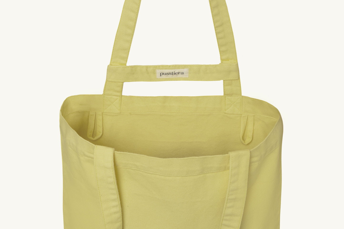 pusstiera tote bag An elegant sustainable cotton canvas tote bag, eco-friendly, premium Swedish design with Scandinavian quality, made in Europe, in limited edition numbered bags. custard lemon color with four utility loops and a stabilizing strap