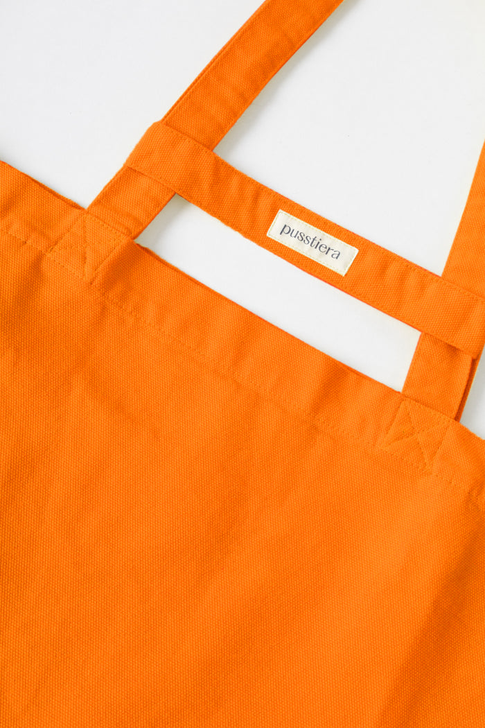 pusstiera tote bag An elegant sustainable cotton canvas tote bag, eco-friendly, premium Swedish design with Scandinavian quality, made in Europe, in limited edition numbered bags. vivd orange color with four utility loops and a stabilizing strap