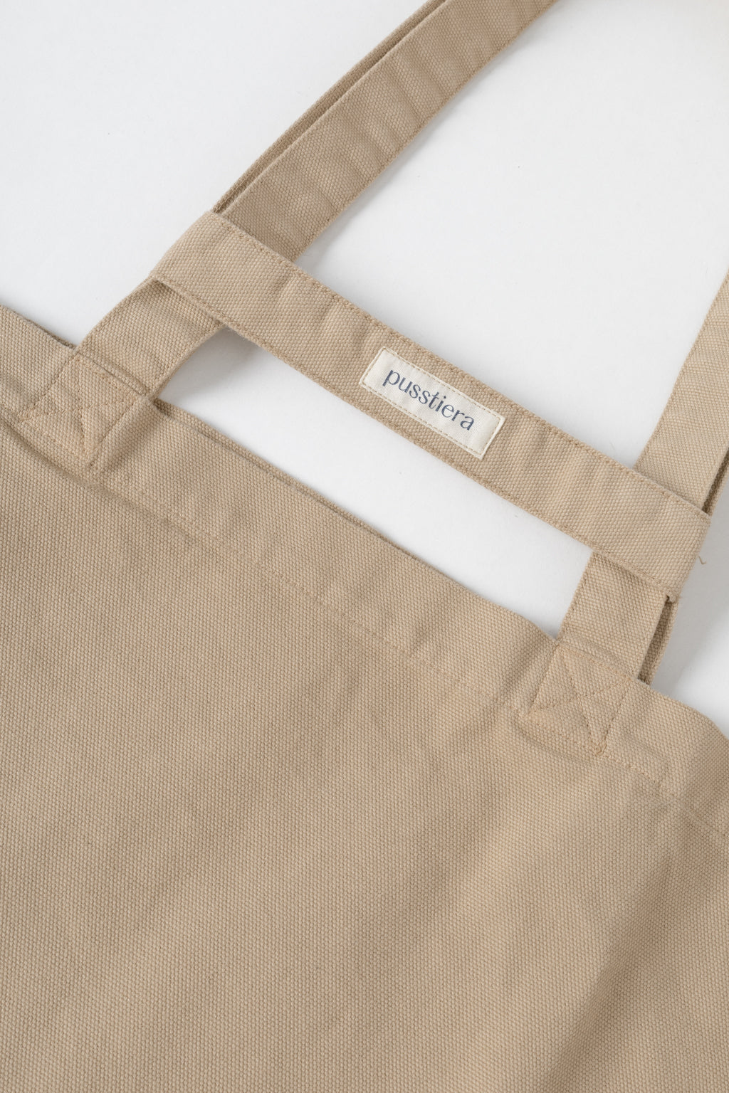 pusstiera tote bag An elegant sustainable cotton canvas tote bag, eco-friendly, premium Swedish design with Scandinavian quality, made in Europe, in limited edition numbered bags. Warm taupe color with four utility loops and a stabilizing strap
